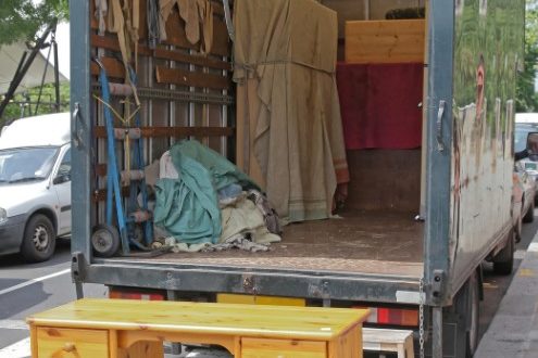 Carga de muebles en el camión Escritorio y muebles sueltos junto al camión durante una recogida en Madrid